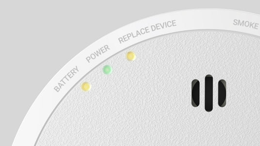 Close-up of a smoke alarm showing the small indicator lights and vent openings.